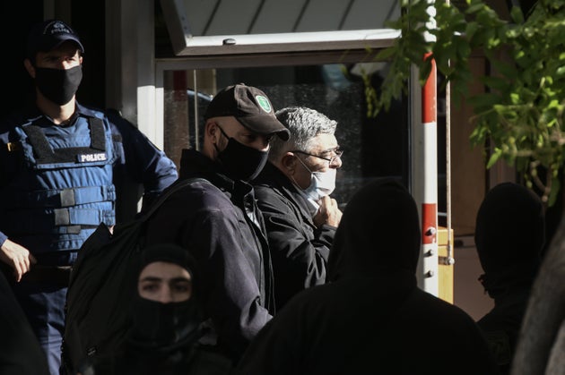 Ο Νίκος Μιχαλολιάκος συνοδεία αστυνομικών οδηγείται στην κλούβα.