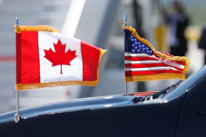 A limousine drives with U.S. and Canadian flags before the arrival of U.S. President Donald Trump at Canadian Forces Base Bagotville in Bagotville, Que. on June 8, 2018 for G7 summit. 