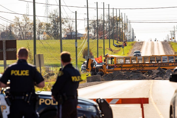 Ontario Provincial Police stand at a blockade on Argyle Street South in Caledonia, Ont., after a judge granted a permanent injunction against a land reclamation camp known as 1492 Land Back Lane on Friday.