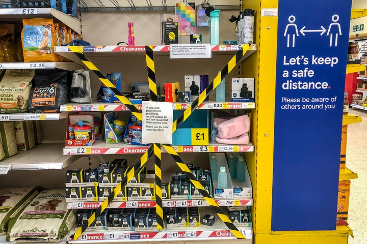 Shelves in a supermarket near Cardiff are deemed non-essential items and are taped off as Wales. 