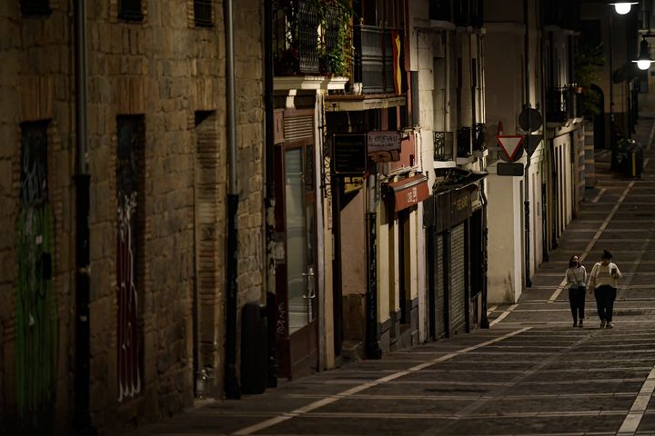 Residents wearing face masks as they walk along an empty Javier street, in Pamplona, northern Spain (AP Photo/Alvaro Barrientos)