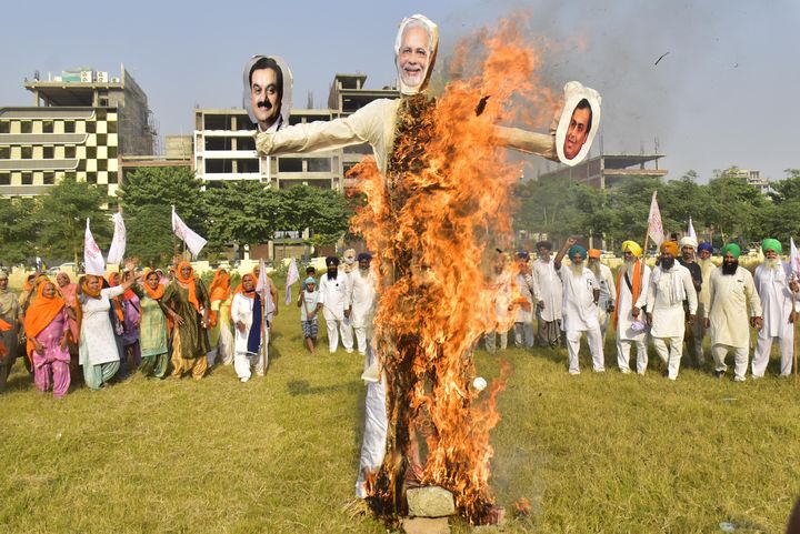 People raise slogans while burning an effigy of Prime Minister Narendra Modi, Chairman of Reliance Industries, Mukesh Ambani and Chairman of the Adani Group Gautam Adani, in protest against corporate businesses under the banner of Kisan Mazdoor Sangharsh Committee, at Ranjeet Avenue Ground, on October 23, 2020 in Amritsar.