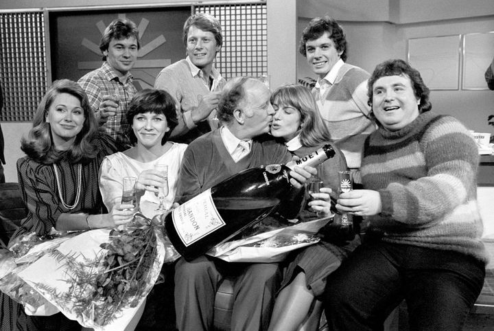 JANUARY 17TH : On this day in 1983 early morning breakfast television began with BBC's 'Breakfast Time'. BBC-TV launched their first Breakfast Time programme at 6:30 and at the closing stages gathered in the studio for a champagne and cake celebration. Left to right: Back row: Weatherman Francis Wilson, Nick Ross and David Icke. Front row: Jane Pauley, an American who runs her own breakfast show, Debbie Rix, Frank Bough kissing Selina Scott and astrologer Russell Grant. (Photo by PA Images via Getty Images)