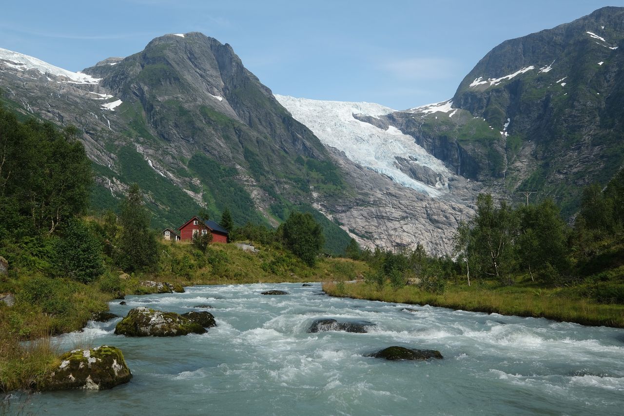 The Boyabreen glacier in Norway lies above rock it ground smooth and once covered deep in ice. Meltwater rushes down a stream past cabins in August 2020.