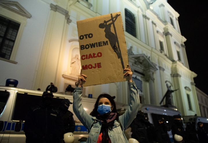 A protester holds a sign during a demonstration against tightening of abortion law in front of the Holy Cross church on October 25, 2020 in Warsaw, Poland. 