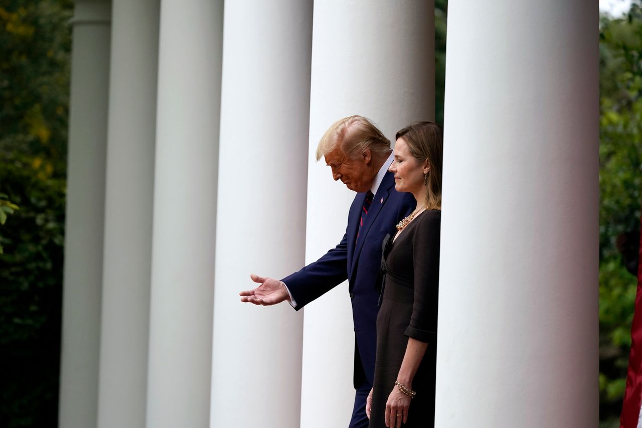 President Donald Trump walks with Judge Amy Coney Barrett to a news conference to announce Barrett as his nominee to the Supreme Court, in the Rose Garden at the White House on Sept. 26 in Washington.