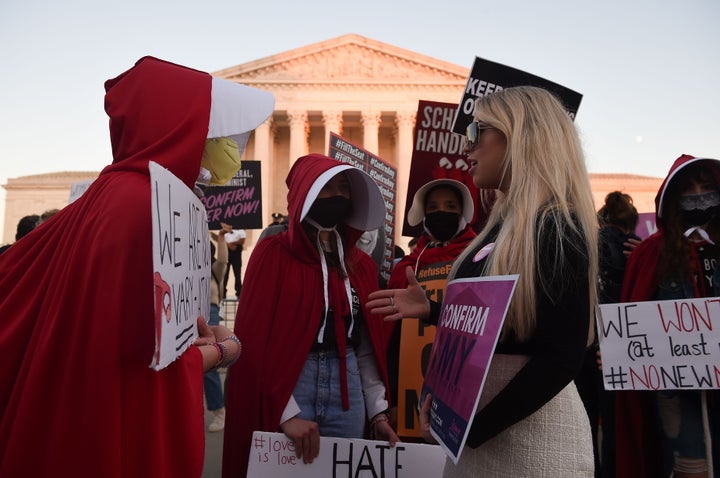 Opponents and supporters of Judge Amy Coney Barrett's nomination confront each other outside the U.S. Supreme Court building on Monday.