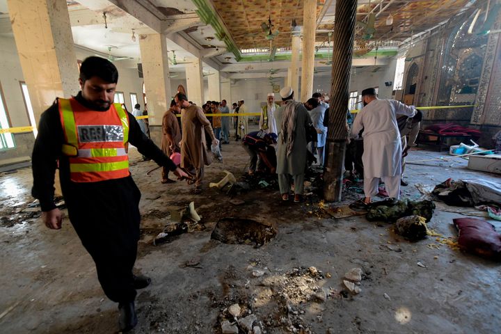 Rescue workers collect remains at the site of a blast in a religious school in Peshawar on Tuesday.