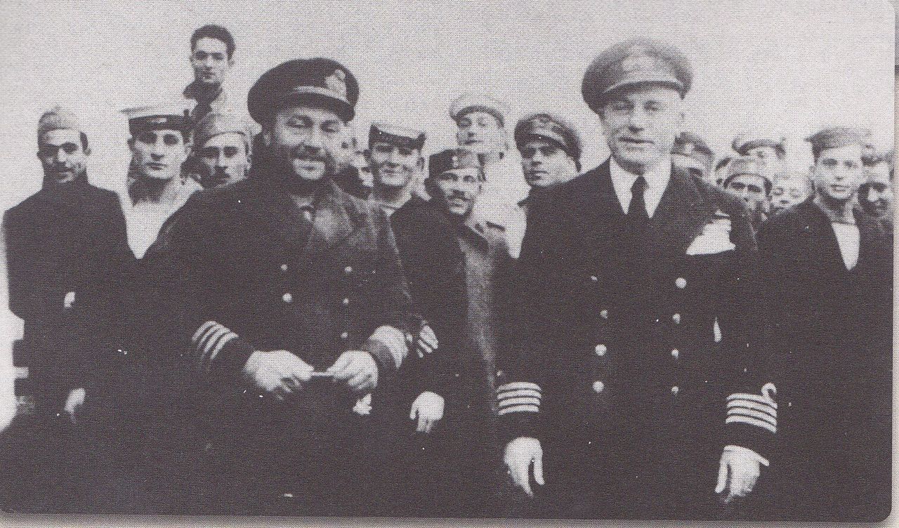 Αριστερά ο Κυβερνήτης του υποβρυχίου «Παπανικολής» Πλοίαρχος Μίλτων Ιατρίδης με τον Πλοίαρχο Αθανάσιο Ξηρό και το πλήρωμα του υποβρυχίου στο Ναύσταθμο, τον Ιανουάριο του 1941.