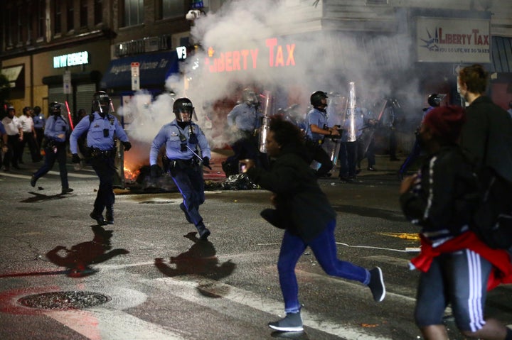 Police charge at a crowd along 52nd Street in West Philadelphia in the early hours of Tuesday, Oct. 27, 2020. Protesters gathered after police shot and killed a Black man in West Philadelphia on Monday. (Tim Tai/The Philadelphia Inquirer via AP)