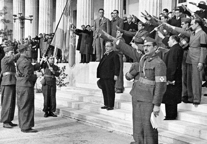 1937 - Ο Μεταξάς ασκεπής σε στάση προσοχής στις σκάλες της Παλαιάς Βουλής πιθανώς σε ανάκρουση Εθνικού Ύμνου.με τους παριστάμενους να αποδίδουν τον φασιστικό χαιρετισμό. Κοντά του είναι οι Κ. Κοτζιάς και ο π. Υπουργός Τουρκοβασίλης. 
