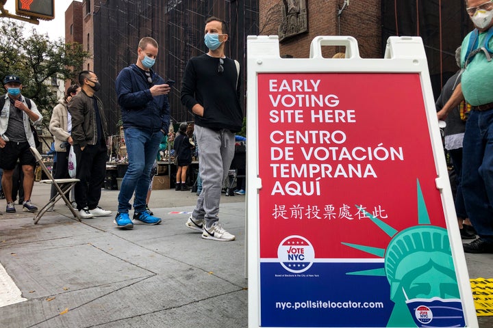 Voters wait in line for a Houston Street polling site on the first day of early voting, Saturday, Oct. 24, 2020, in New York.