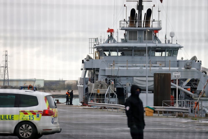 A policeman stands next to a rescue vessel during a search operation after a boat carrying at least 18 migrants capsized off the coast of Loon-Plage near Dunkirk, northern France.