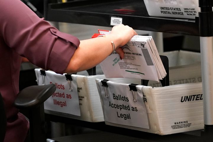 An election worker sorts vote-by-mail ballots at the Miami-Dade County Board of Elections, Monday, Oct. 26, 2020, in Doral, Fla.
