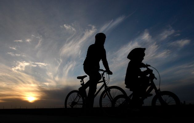 Ενας άνδρας κι ένα παιδί κάνουν ποδήλατο κατά μήκος της παραλίας Σεν Κίλντα στην Μελβούρνη.