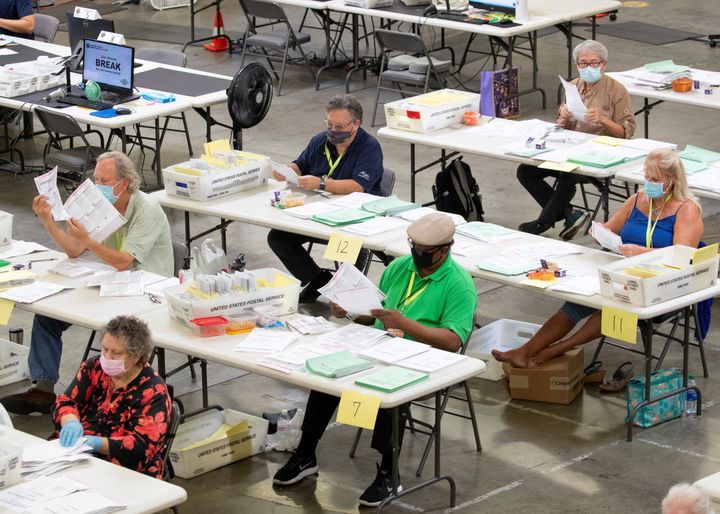 Election workers look over some of the hundreds of thousands of mail-in ballots as they are processed Oct. 16 at the Orange County Registrar of Voters in Santa Ana, California.