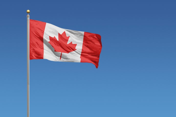 A Canadian flag on a flagpole. 