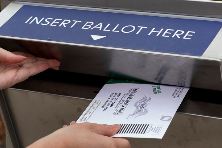 Nikki Schueller inserts her absentee voter ballot into a dropbox in Troy, Michigan, on Oct. 15.