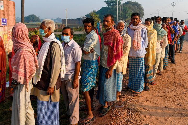 Voters wait to cast their ballot at a polling station in Patna on October 28, 2020.