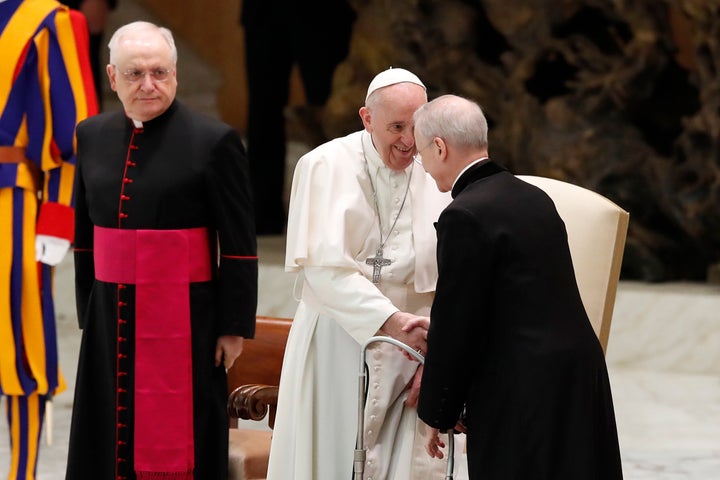 Pope Francis shakes hands with Monsignor Luis Maria Rodrigo Ewart as he arrives in the Paul VI Hall at the Vatican for his we