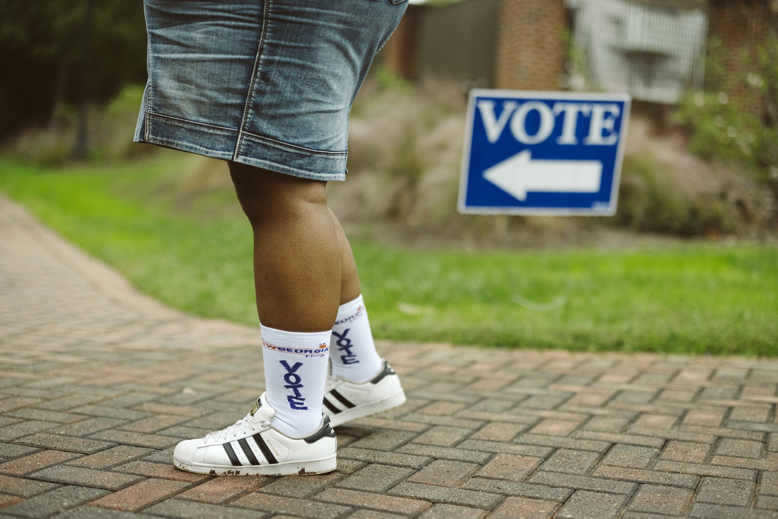 Ría Thompson-Washington wears "Vote" socks while posing for a portrait at Agnes Scott College in Decatur, Georgia, on