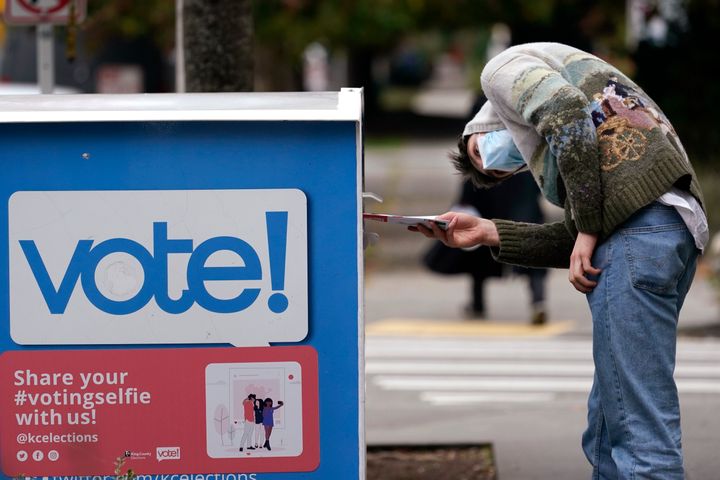 ワシントン州シアトルで投票ボックスに票を入れる有権者（2020年10月28日）