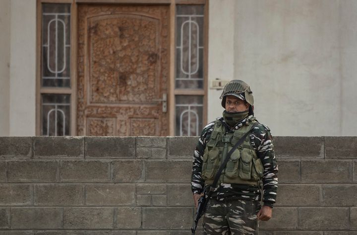 A soldier stands guard as National Investigation Agency personnel search the premises of AFP's Kashmir correspondent Parvaiz Bukhari on the outskirts of Srinagar on October 28, 2020.