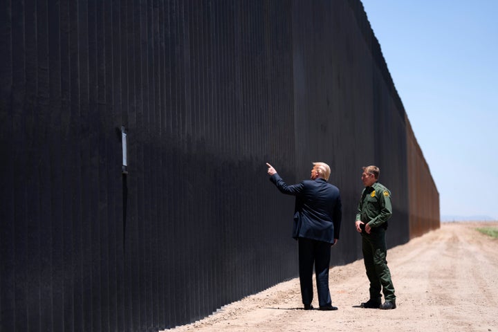 El presidente Donald Trump habla con Rodney Scott, el jefe de la Patrulla Fronteriza, mientras recorre una sección del muro fronterizo en San Luis, Arizona, el martes 23 de junio de 2020.