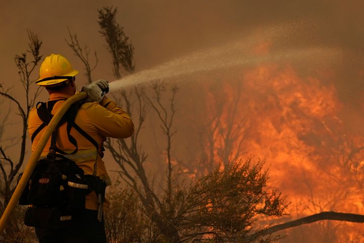 Jesse Vasquez, del Departamento de Bomberos del condado San Bernardino, rocía agua sobre el fuego en Valyermo, California, el sábado 19 de septiembre de 2020.