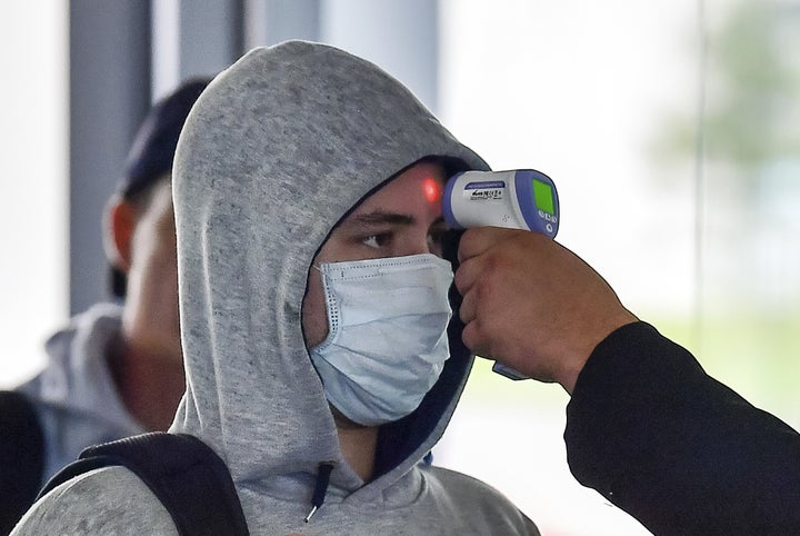 Una persona toma la temperatura a un hombre.