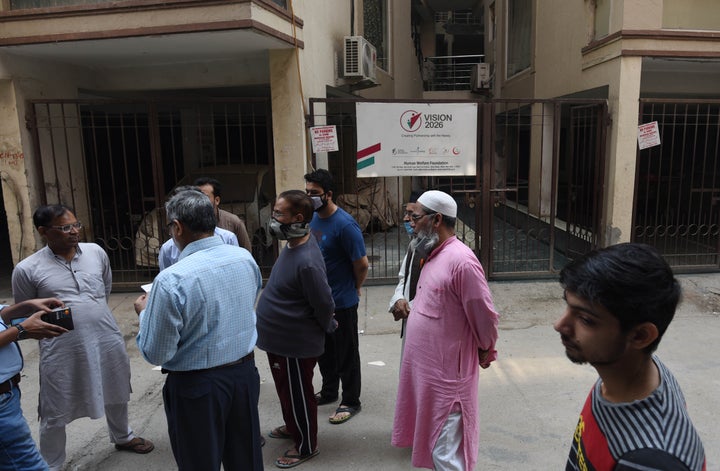 People assembled outside the entrance gate to the Human Welfare NGO office where Delhi police conducted a raid this morning at Abul Fazal Enclave, in Jamia Nagar, on October 29, 2020 in New Delhi.