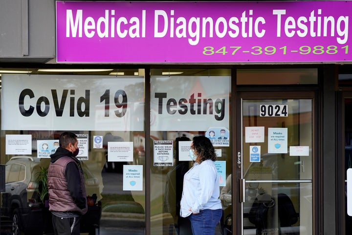 Una empleada de Exam Corp Lab habla con un paciente formado para realizarse una prueba de COVID-19 en Niles, Illinois, el miércoles 21 de octubre de 2020.