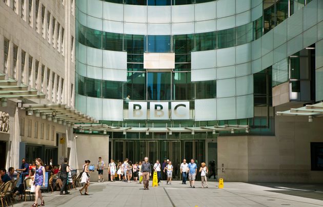 London, UK - July 3, 2014:  BBC head office and square in front of main entrance with walking people