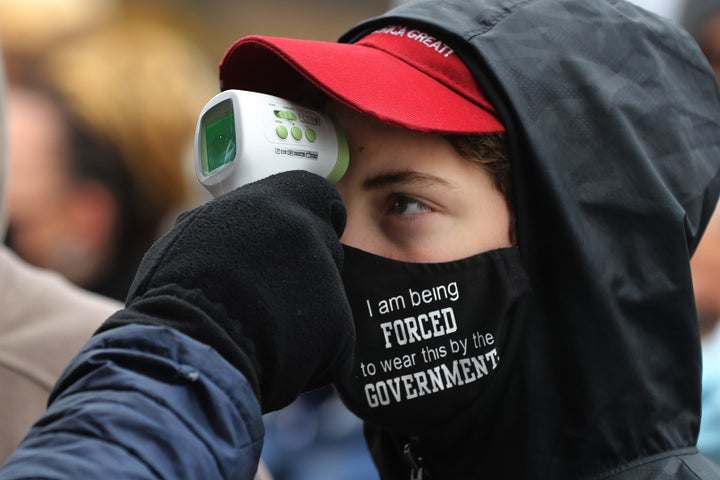 Supporters of President Donald Trump have their temperature taken as a precaution against the coronavirus before attending a campaign rally at Capital Region International Airport Oct. 27 in Lansing, Michigan.