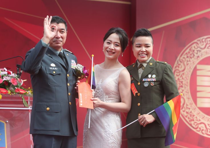 Yi Wang, right, Yumi Meng and General Chen Pao-Yu pose for a photo during a military mass wedding ceremony in Taoyuan city, northern Taiwan. (AP Photo/Chiang Ying-ying)