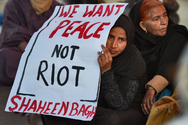 Women hold a placard during the ongoing sit-in protest against NPR, NRC and CAA after Supreme Court deferred the hearing on petitions to remove the anti-citizenship law protesters from Shaheen Bagh, on February 26, 2020 in New Delhi, India. 