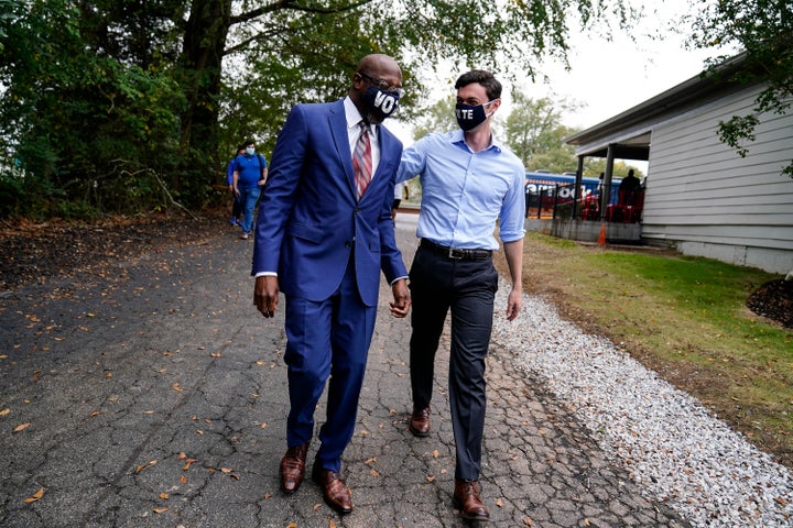 Democratic candidate for Senate Jon Ossoff, right, and Democratic candidate for Senate Raphael G Warnock, left, arrive before they speak to a crowd during a "Get Out the Early Vote" event at the SluttyVegan ATL restaurant on Tuesday, Oct. 27, 2020, in Jonesboro, Ga. (AP Photo/Brynn Anderson)