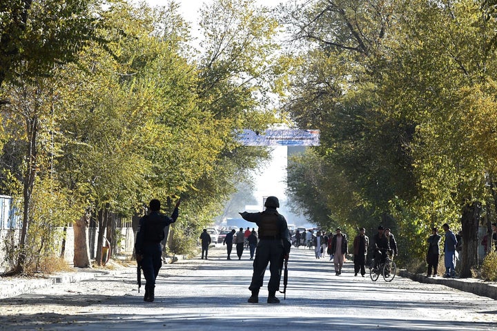 Security personnel gesture to onlookers while securing an area near the Kabul University in Kabul on November 2, 2020. (Photo