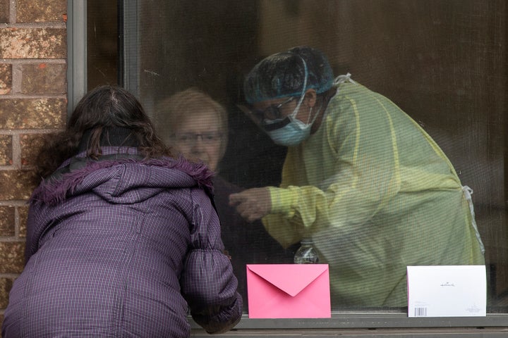 A resident at Orchard Villa Care home in Pickering, Ont., receives a Mother's Day visit from her family, on May 10, 2020.