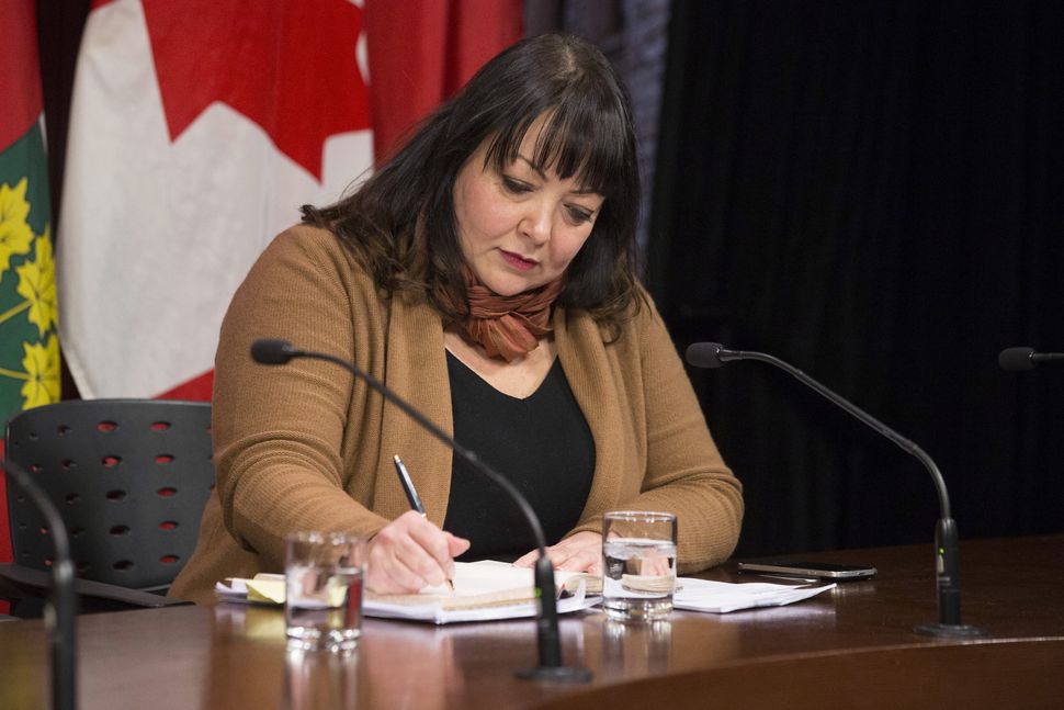 Natalie Mehra, executive director of the Ontario Health Coalition, makes a note before speaking to reporters at Queen's Park in Toronto on Jan. 21, 2019.