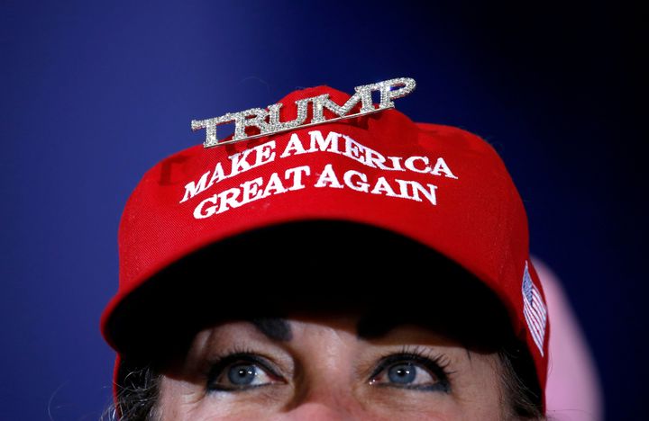 「Make America Great Again（アメリカを再び偉大に）」とかかれた帽子をかぶる人