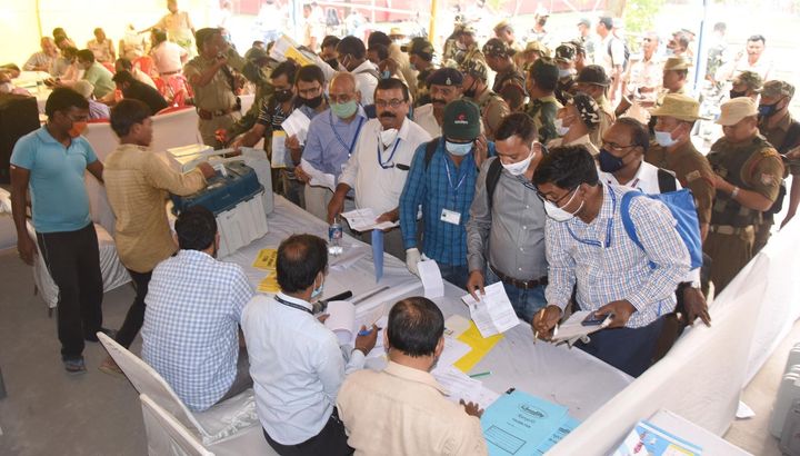 Polling officers complete paperwork to receive VVPAT and EVM machines from a distribution centre ahead of the second phase of Bihar assembly election, at B.S. College, Danapur on November 2, 2020 in Patna. 