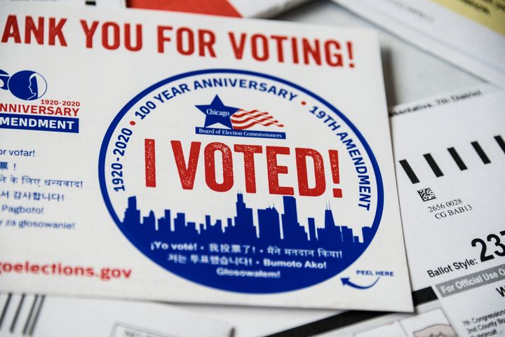 Close up of Sticker with I Voted! printed legend and other paper work.The Voting-by-mail allows voters who cannot or do not want to visit the polls on Election Day, to cast their ballot by the US mail.