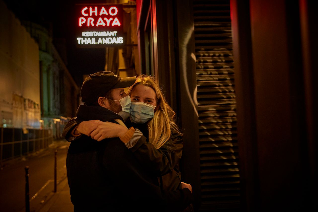 Ζευγάρι με μάσκες στο Παρίσι περιμένει έξω από να πάρει φαγητό από ένα εστιατόριο