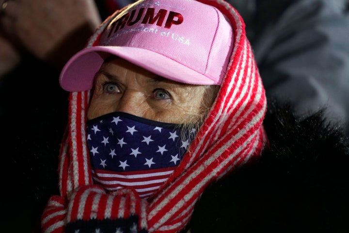 A supporter of President Donald Trump listens to him speak during a campaign rally at Gerald R. Ford International Airport, early Tuesday, Nov. 3, 2020, in Grand Rapids, Mich. (AP Photo/Evan Vucci)