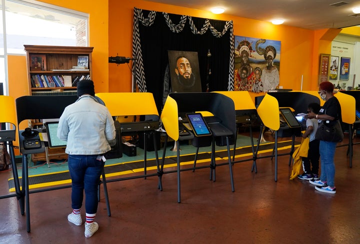 Voters work on their ballots at a polling station at the Hot and Cool Cafe, Tuesday, Nov. 3, 2020, in the Leimert Park section of Los Angeles.