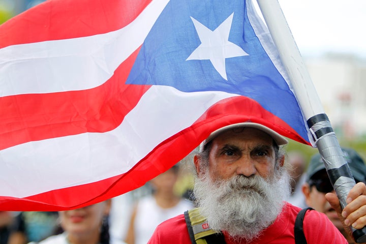 A man carries a Puerto Rican flag during a protest against the referendum for Puerto Rico political status in San Juan.