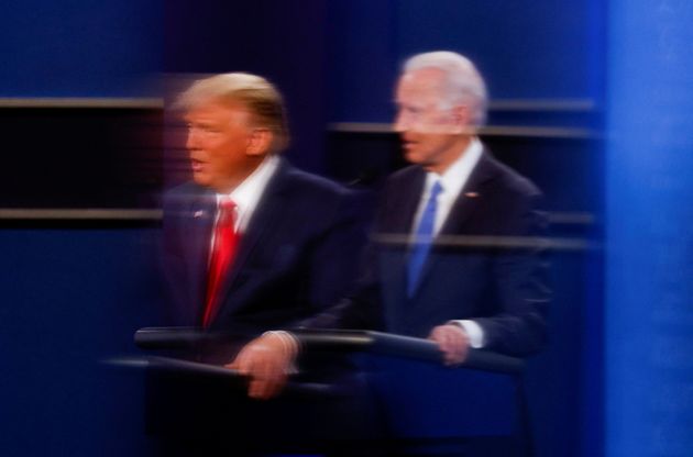 US President Donald Trump and Democratic presidential candidate Joe Biden are reflected in the plexiglass ...