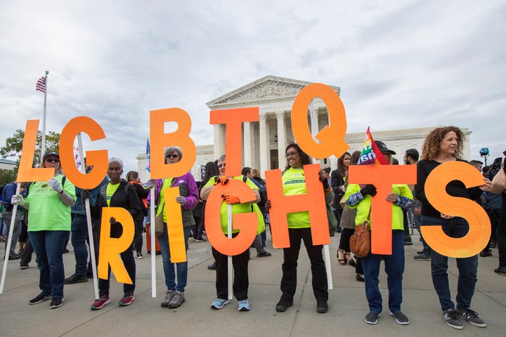 Supporters of LGBTQ rights hold placards in front of the U.S. Supreme Court, Tuesday, Oct. 8, 2019, in Washington. 