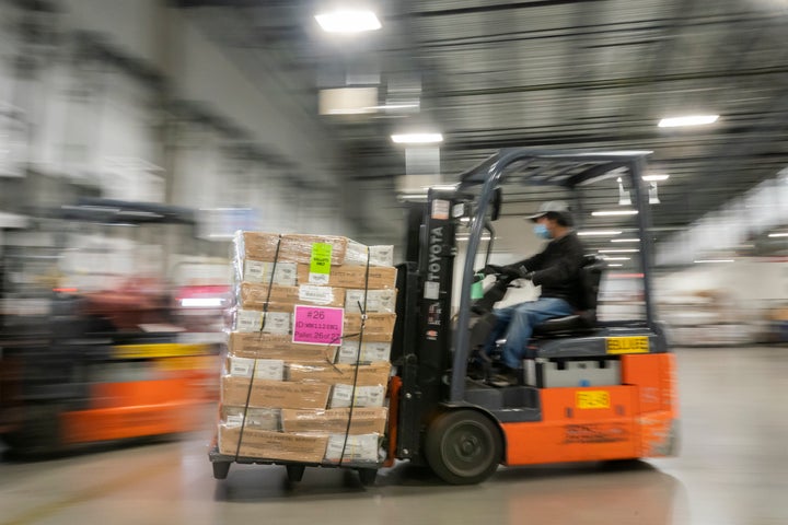 A mail handler unloads pallets filled with Washington and Oregon mail-in ballots at a U.S. Postal Service processing and distribution center on Oct. 14, 2020, in Portland, Oregon.